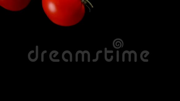 番茄正落在黑色的背景上视频的预览图