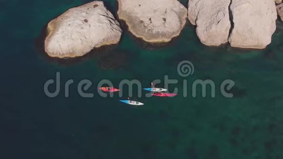 皮划艇上的空中游客在岩石海岸上航行视频的预览图