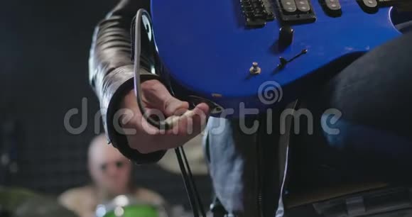 将蓝色吉他与放大器连接起来的音乐家手视频的预览图