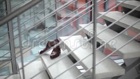 新郎男鞋站在婚礼前的台阶上视频的预览图