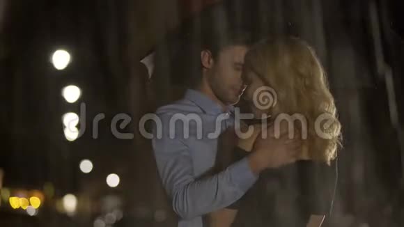 男人在雨中抚摸他的金发女朋友一对等待出租车的夫妇爱视频的预览图