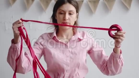专业的女性花店把红丝带解开用剪刀剪开包装花束视频的预览图