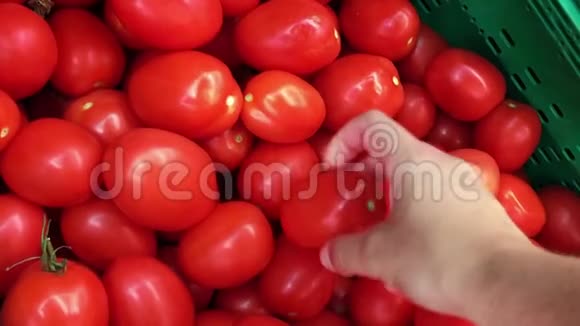 在超市里捡新鲜西红柿的人的手视频的预览图
