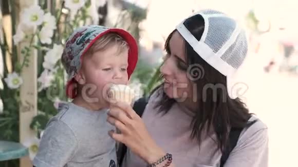 一位慈爱的母亲给她的孩子喂冰淇淋一个小男孩吃得很开心精神很高脸很脏视频的预览图