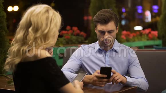 已婚夫妇不注意彼此在智能手机上滚动页面视频的预览图