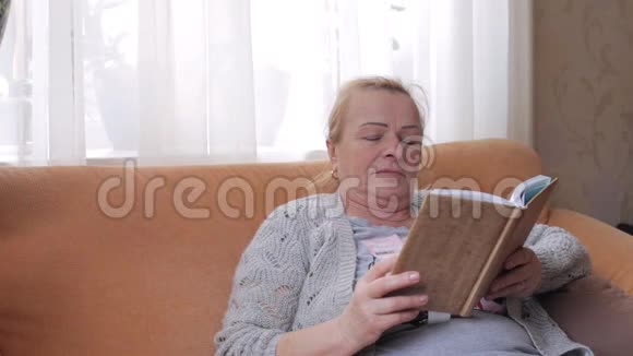 坐在沙发上看书的老妇人视频的预览图