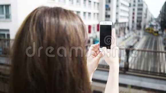 年轻女子用智能手机拍摄德国城市的照片视频的预览图