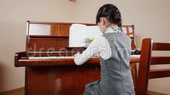 音乐课弹钢琴的女孩从女孩的背后看游戏的画面视频的预览图
