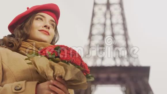 在埃菲尔铁塔背景下欣赏一束红玫瑰的美丽女孩视频的预览图