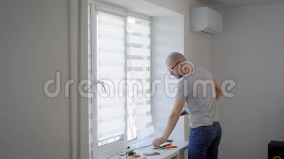 安装窗户的师傅是用电动螺丝刀在家里的白光室里的一个框架里旋转视频的预览图