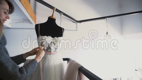有魅力的年轻时尚设计师女士在家庭工作室工作裁缝做婚纱视频的预览图