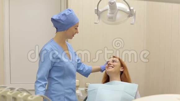 年轻漂亮的女孩在牙科办公室和她的牙医交谈视频的预览图