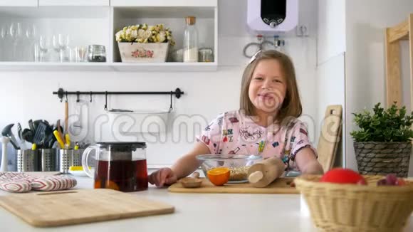 小女孩拿着茶壶在厨房里笑视频的预览图