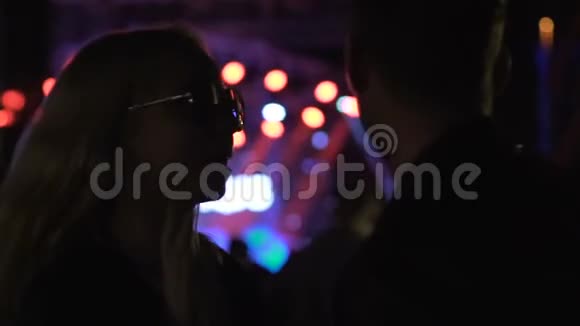 戴着墨镜的美女和男朋友在晚上的演唱会上混视频的预览图