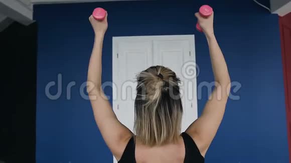 后景健身运动训练和人的概念快乐的年轻女子与粉红色哑铃锻炼视频的预览图