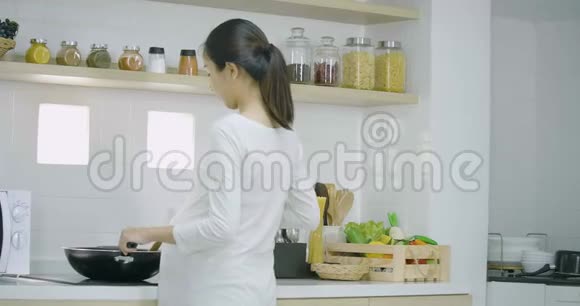 孕妇和她的丈夫一起在家里的厨房准备健康的食物视频的预览图