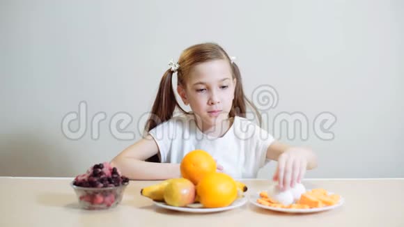 女孩吃胡萝卜被戒指切成薄片坐在厨房的桌子旁素食健康饮食健康蔬菜视频的预览图