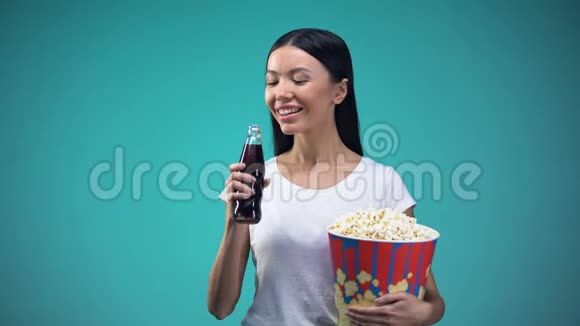 亚洲妇女拿着大纸杯和爆米花喝着苏打水参观电影院视频的预览图