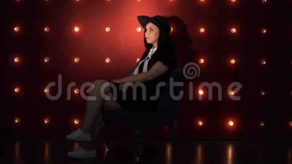 戴帽子的年轻女子靠在明亮的墙上视频的预览图