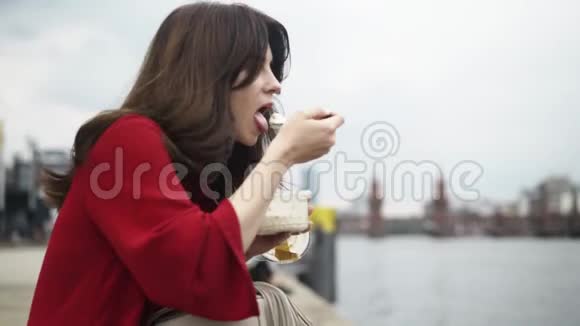一位美丽的年轻女子夏天在德国街头吃饭潘射球视频的预览图