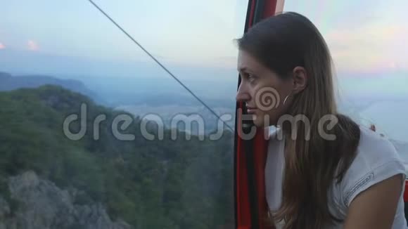 年轻的女游客坐在缆车上移动视频的预览图