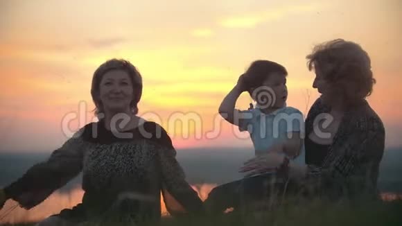 祖母日落时分带着小儿子的母亲在山上拍打蚊子视频的预览图