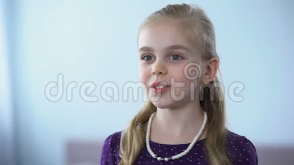 戴着珍珠项链的漂亮小女孩照镜子欣赏倒影视频的预览图