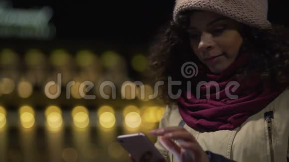 美丽的女孩在手机上读浪漫的爱情信件微笑着视频的预览图