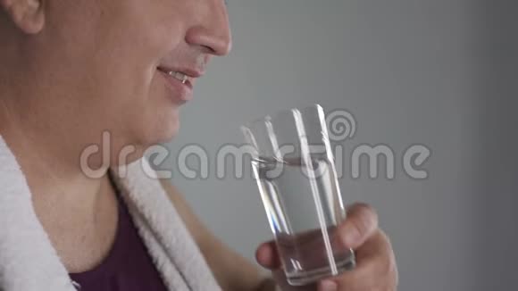 矮胖的男人喝着杯子里的新鲜水微笑着节食视频的预览图