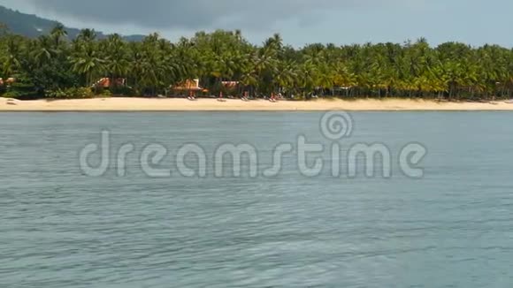 沙滩与泰国传统风格的小茅屋和平静的海洋苏梅岛泰国绿色椰子棕榈树视频的预览图