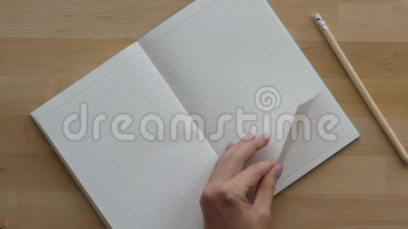 女人手在笔记本上挥起干净的书页视频的预览图