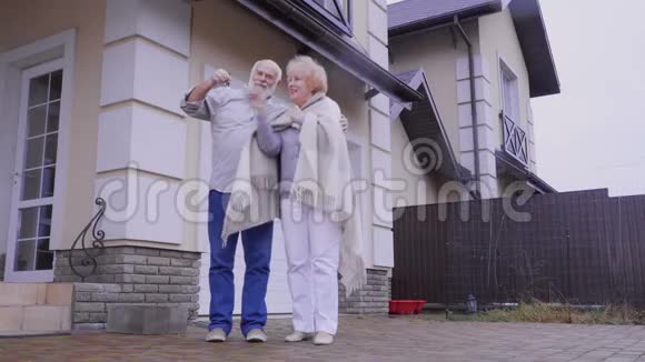 一对快乐的老夫妇带着户外新房子的钥匙视频的预览图