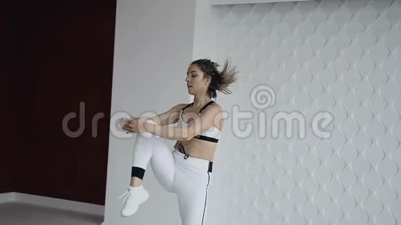 运动女孩在健身房训练前为热身表演跳跃适合金发女郎做普拉提在工作室搬家白人女孩视频的预览图