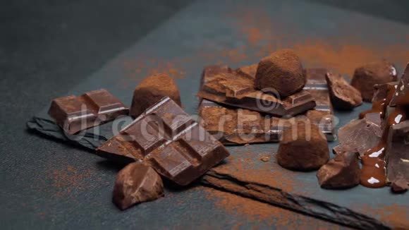 深色或牛奶巧克力片巧克力糖浆和深色混凝土背景的松露糖果视频的预览图