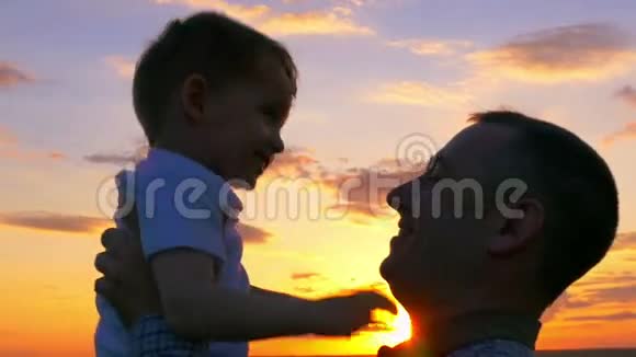 日落时分的父子爸爸把儿子抱在怀里亲吻视频的预览图