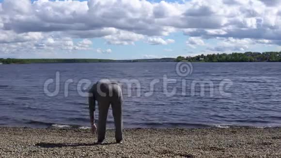 在湖边做热身运动的年轻人视频的预览图