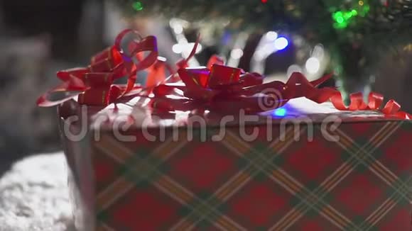 两岁的小男孩得到了一份礼物礼物上有一根红丝带还有一棵圣诞树还有很多礼物盒视频的预览图