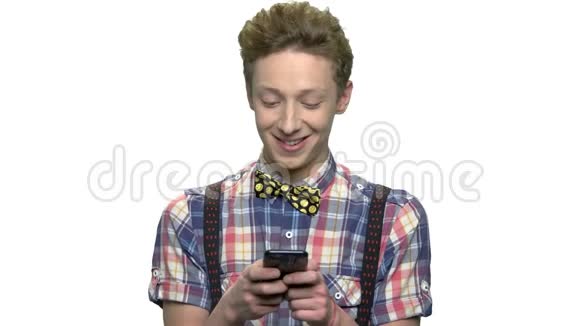 微笑的十几岁的男孩使用手机视频的预览图