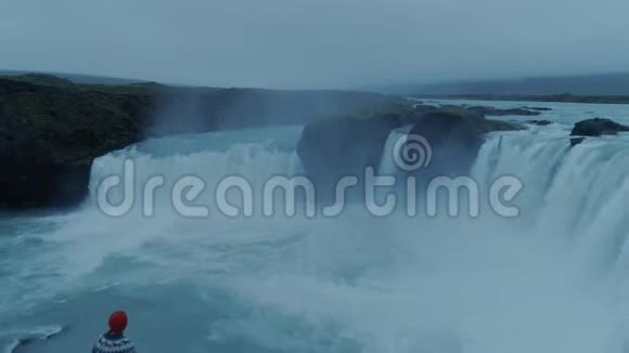 黄昏的冰岛瀑布上孤独的人视频的预览图