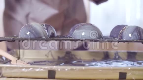 糕点师的手用蜡烛油洒釉球视频的预览图