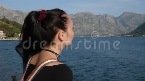 女游客看着风景如画的海湾视频的预览图