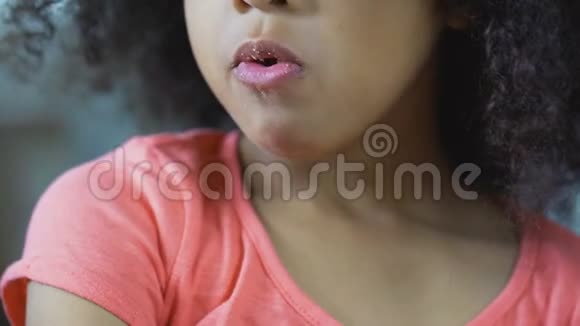关闭非裔美国女孩子咀嚼饼干不健康的食物视频的预览图