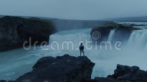 黄昏的冰岛瀑布上孤独的人视频的预览图