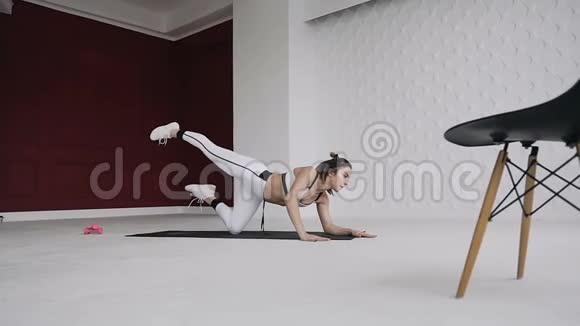 年轻的金发女人在她的肘部做瑜伽姿势的运动健身训练健身地板上的印子是白色的视频的预览图