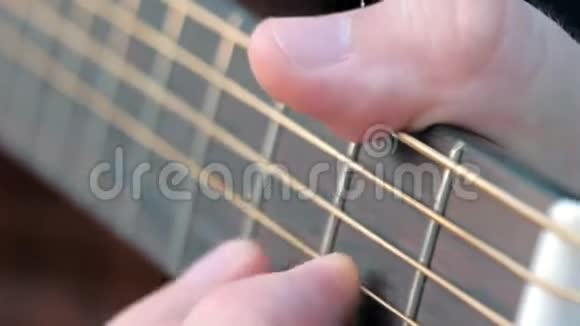 特写侧角弹指弹吉他音乐家把和弦夹在吉他上感到不安视频的预览图