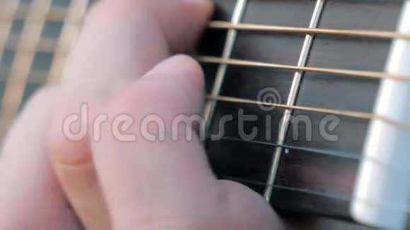 特写侧角弹指弹吉他音乐家把和弦夹在吉他上感到不安视频的预览图