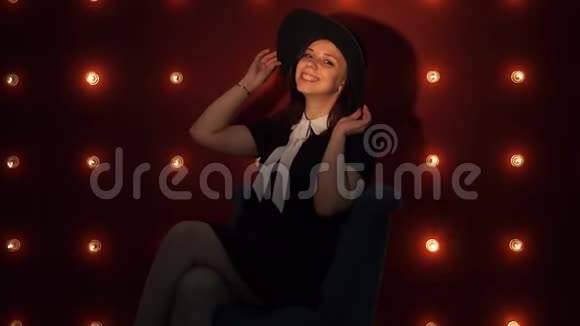 戴帽子的年轻女子靠在明亮的墙上视频的预览图