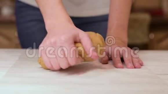 女人的手在厨房的桌子上揉面团视频的预览图