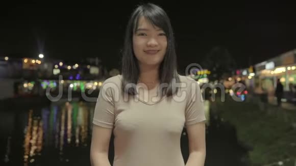 一个年轻的年轻的亚洲女人在市区的街头旅行时会高兴地微笑着视频的预览图