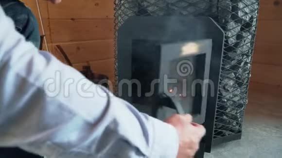 人在桑拿中点燃炉子在桑拿中点燃木头炉子视频的预览图